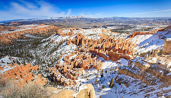 Red and white hoodoo rock formations in snow in Bryce Canyon National Park, Utah.
