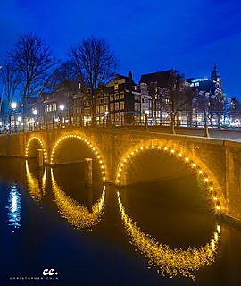 A canal lit after dark in Amsterdam.