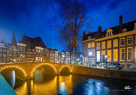 Bridges and reflections at night in Amsterdam.