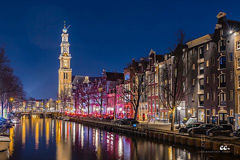 A canal lit after dark in Amsterdam.